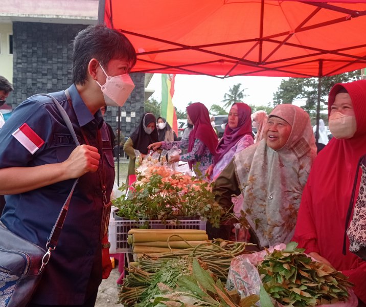 Deputi BI Perwakilan Riau Maria Cahyaningtyas saat akan membeli sayur yang dijual pedagang di pasar murah, Rabu (9/11/2022). Foto: Surya/Riau1.