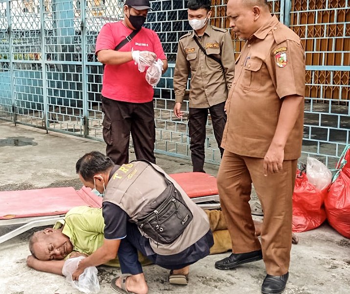 Tim Dinsos Pekanbaru mengevakuasi orang telantar di Jalan Tuanku Tambusai. Foto: Istimewa.
