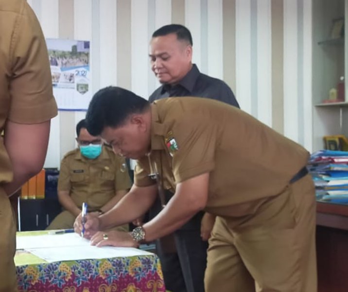 Kepala Disnaker Abdul Jamal menandatangani dokumen sebagai Plt Kepala Disdik disaksikan Ismardi Ilyas yang mengundurkan diri, Senin (21/11/2022). Foto: Istimewa