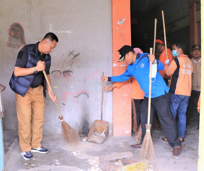 Pj Sekdako Pekanbaru Indra Pomi Nasution saat menyapu lorong kios Pasar Sail, Minggu (11/12/2022). Foto: Istimewa.