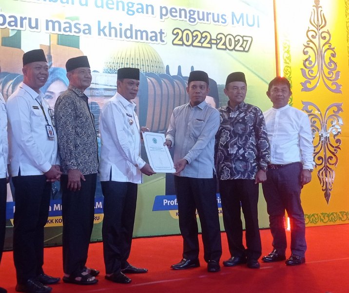 Ketua MUI Pekanbaru Profesor Akbarizan menyerahkan SK pengurus masa khidmat 2022-2027 kepada Pj Wali Kota Muflihun di rumah dinas, Rabu (14/12/2022). Foto: Surya/Riau1.