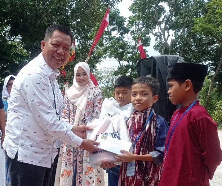Pj Sekdako Pekanbaru Indra Pomi Nasution menyerahkan hadiah kepada anak yang baru selesai dikhitan di halaman Kantor Kecamatan Payung Sekaki, Rabu (21/12/2022). Foto: Surya/Riau1.