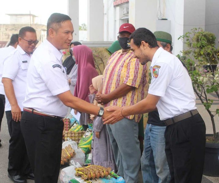 Kepala Bapenda Pekanbaru Alek Kurniawan saat penyaluran zakat dan bahan pokok kepasa mustahik di halaman kantornya, Rabu (21/12/2022). Foto: Istimewa.