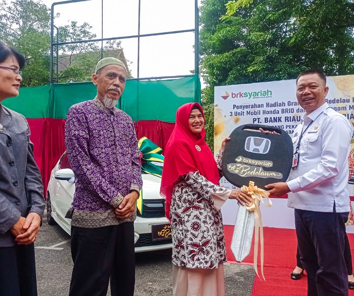 Pj Sekdako Pekanbaru Indra Pomi Nasution menyerahkan kunci mobil Honda Brio secara simbolis di Kantor BRK Syariah Cabang Pekanbaru, Rabu (11/1/2023). Foto: Surya/Riau1.