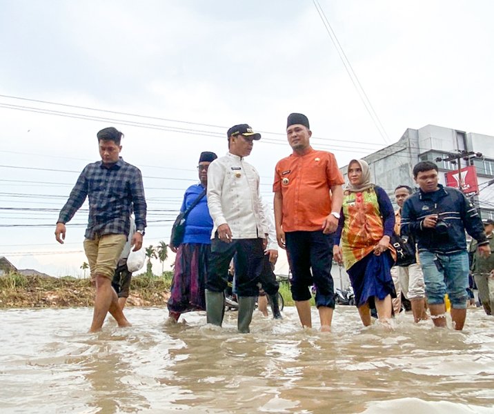 Pj Wali Kota Pekanbaru Muflihun saat meninjau banjir di Jalan Darma Bakti Sigunggung bersama lurah dan camat, Jumat (13/1/2023). Foto: Istimewa.