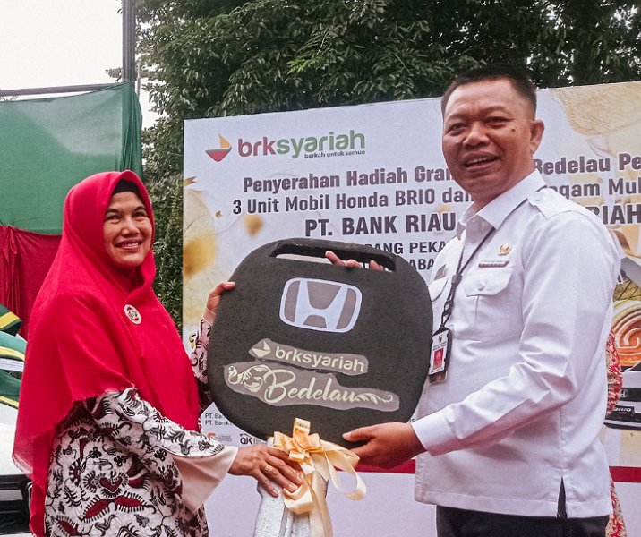Asmia, saat menerima kunci mobi Honda Brio secara simbolis dari Pj Sekdako Pekanbaru Indra Pomi di Kantor Cabang BRK Syariah pada 11 Januari 2023. Foto: Surya/Riau1.