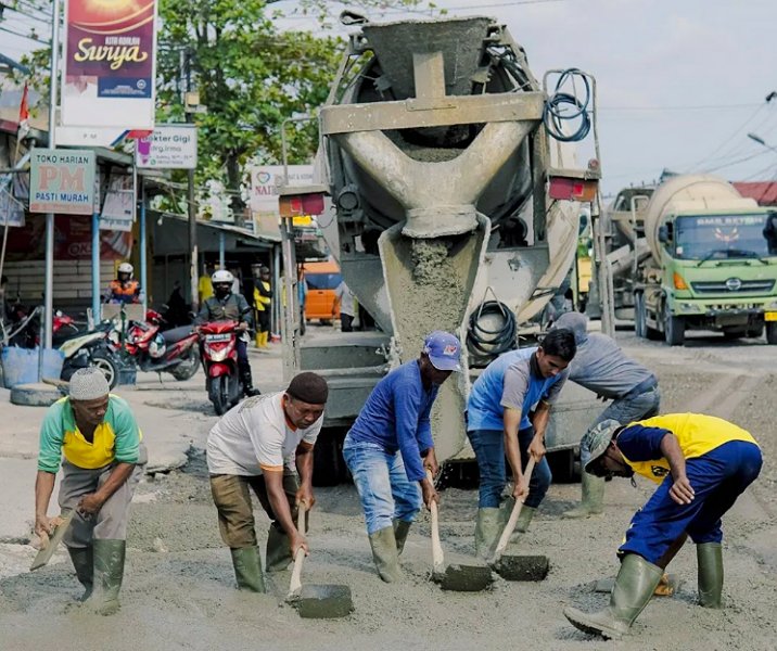 Pekerja Dinas PUPR Pekanbaru saat meratakan cor semen di Jalan Darma Bakti (Sigunggung) pada 16 Januari lalu. Foto: Istimewa.