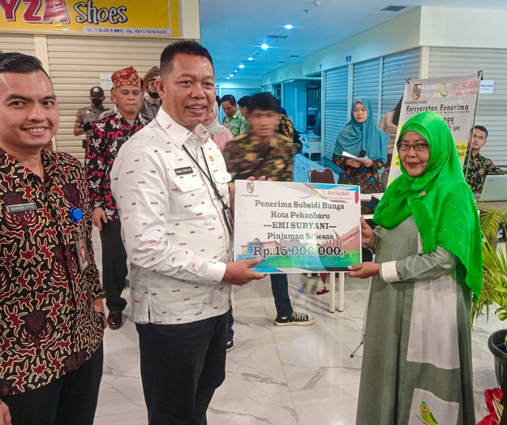 Pj Sekdako Pekanbaru Indra Pomi Nasution didampingi Dirut Bank Pekanbaru Akhmad Fauzi menyerahkan secara simbolis bantuan subsidi bunga pinjaman kepada pelaku UMKM secara simbolis di STC, Kamis (26/1/2023). Foto: Istimewa.