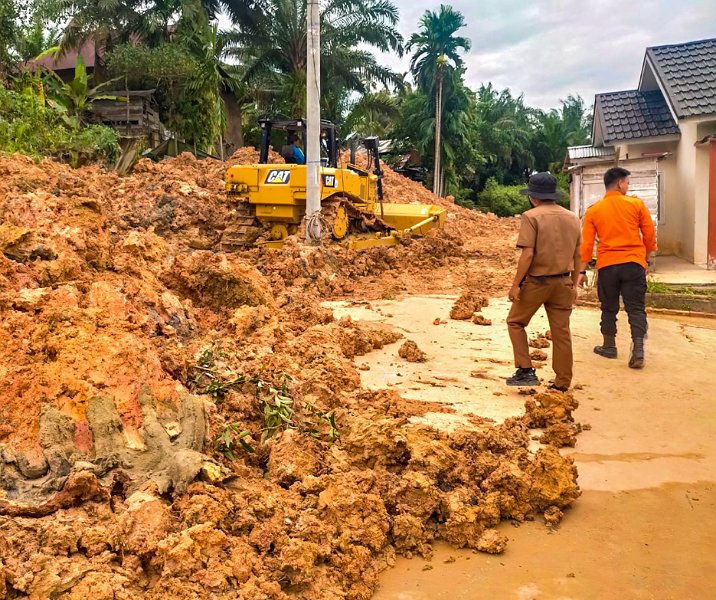 Alat berat Dinas PUPR Pekanbaru membersihkan material longsor di Perumahan Panorama Indah Residence 2 Tenayan Raya, Selasa (31/1/2023). Foto: BPBD.