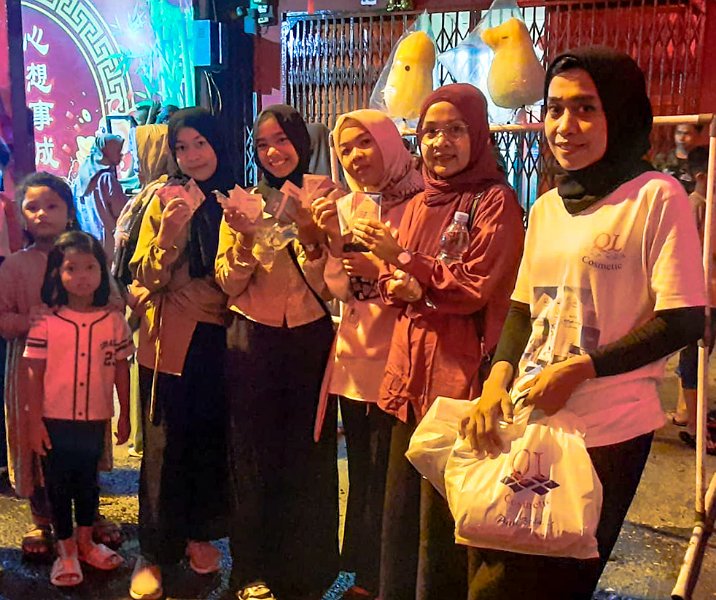 QL Cosmetic membagikan produk terbaru kepada warga di malam perayaan Imlek di Jalan Karet, Pekanbaru, pada 21 Jamuari 2023. Foto: Istimewa.