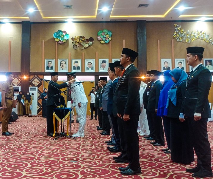 Sekdako Pekanbaru Indra Pomi Nasution memasang tanda jabatan bagi Raja Faisal yang dilantik sebagai Camat Kulim di aula Gedung Utama Kompleks Perkantoran Tenayan Raya, Senin (20/2/2023). Foto: Surya/Riau1.