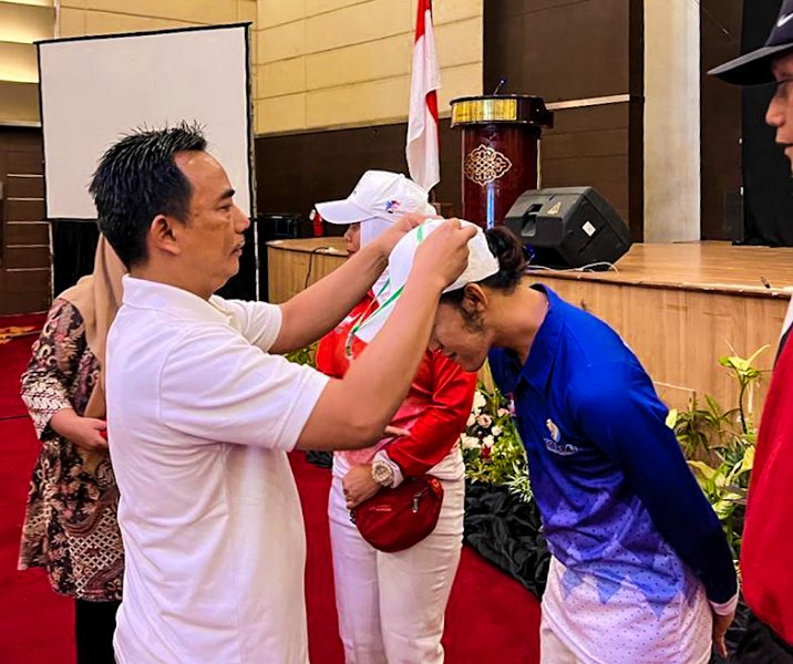 Kepala Dispora Kota Pekanbaru Hazli Fendriyanto saat mengalungkan kartu tanda peserta sosialisasi SKJ. Foto: Istimewa.