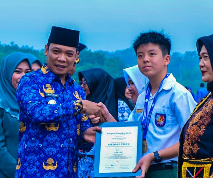 Howard Valero Hansen dari SD Darma Yudha, salah seorang pelajar Pekanbaru yang meraih medali emas di tingkat nasional, menerima piagam penghargaan dari Pj Wali Kota Muflihun, Selasa (2/3/2023). Foto: Istimewa.