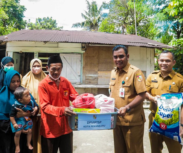 Kepala DPMPTSP Pekanbaru Akmal Khairi didampingi Sekretaris Norpendike saat menyalurkan bantuan ke keluarga anak berisiko stunting di Kelurahan Sialang Munggu, Selasa (9/5/2023). Foto: Istimewa.