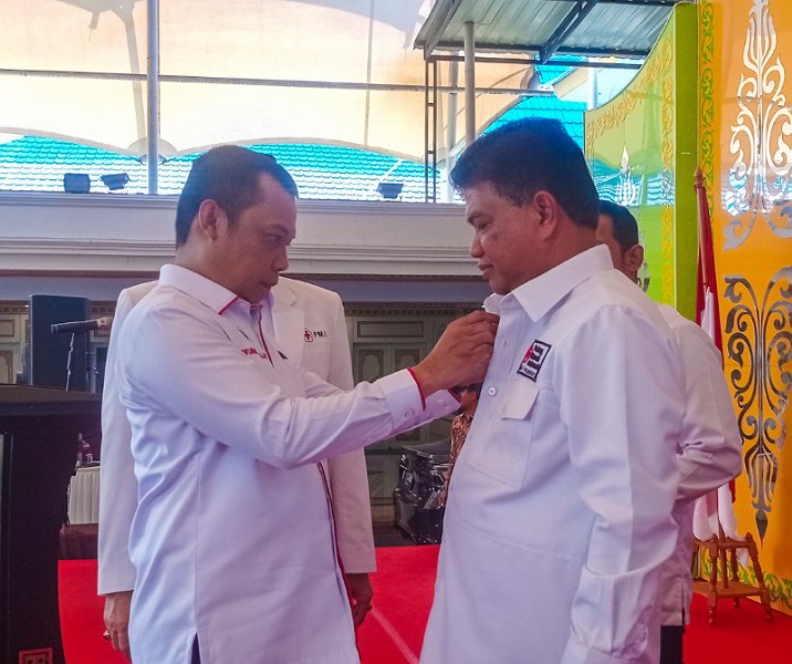Pj Wali Kota Pekanbaru Muflihun menyematkan pin kepada Ketua PMI Abdul Jamal saat proses pelantikan di rumah dinas wali kota, Sabtu (13/5/2023). Foto: Istimewa.