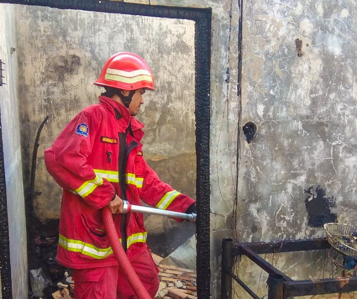 Petugas pemadam memadamkan kebakaran rumah warga di Desa Kualu, Kampar, Sabtu (13/5/2023) pagi. Foto: Istimewa.