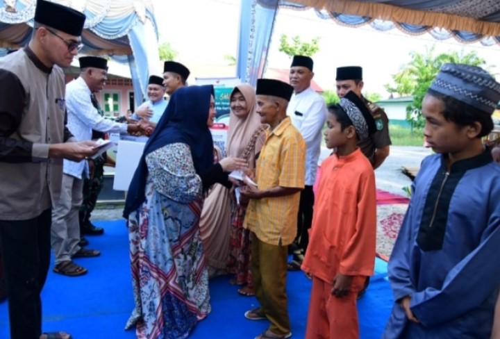 Bupati Kasmarni saat menyerahkan bantuan kepada anak Yatim dan kaum dhuafa