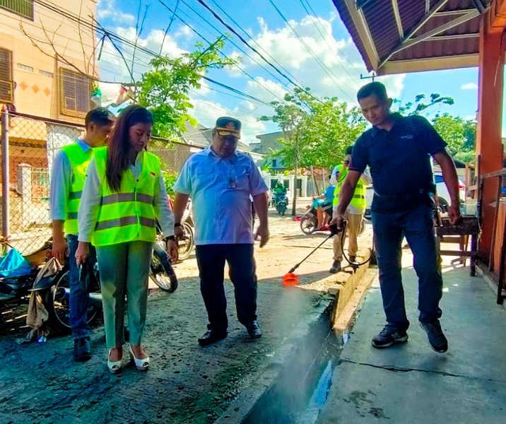 Kepala DLHK Pekanbaru Hendra Afriadi menyaksikan kinerja cairan Ecotru dari guna membasmi bau limbah di Pasar Limapuluh, kemarin. Foto: Istimewa.