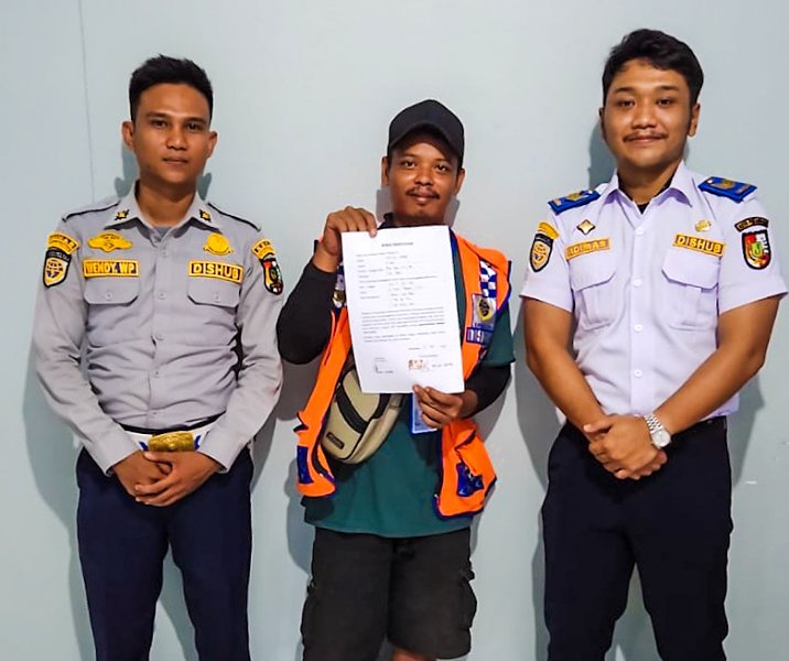 Jukir ini mendapat teguran karena bekerja mengenakan celana pendek. Foto: Istimewa.