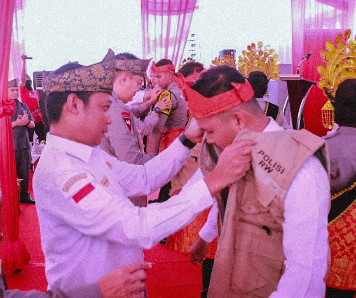 Pj Wali Kota Pekanbaru Muflihun memasangkan rompi Polisi RW kepada anggota Polri di halaman kantor gubernur Riau, Rabu (14/6/2023). Foto: Istimewa.