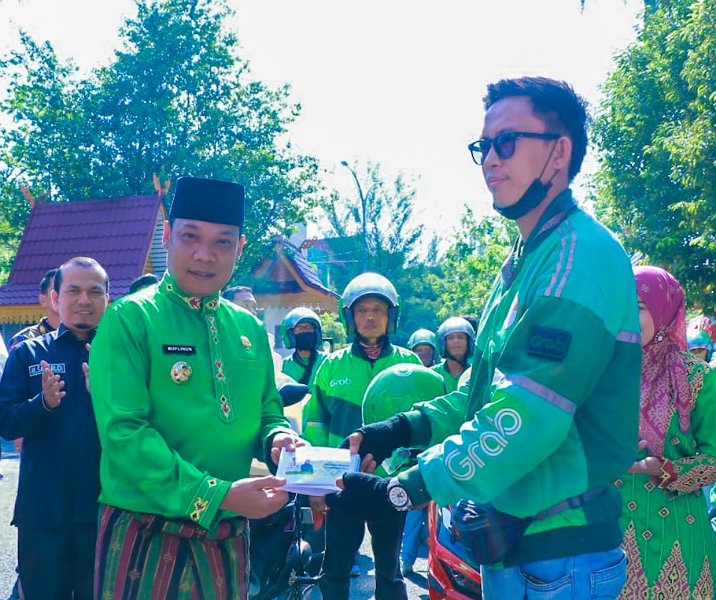Pj Wali Kota Pekanbaru menyerahkan dokumen kependudukan ke pengendara Grab Andong untuk diantar ke rumah warga. Foto: Istimewa.