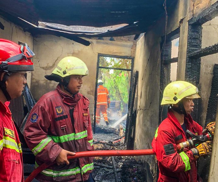 Petugas damkar saat proses pendinginan rumah yang terbakar di Meranti Pandak, Kamis (22/6/2023). Foto: Istimewa.