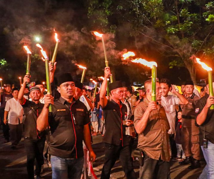 Warga membawa obor dalam rangka memeriahkan malam takbiran Hari Raya Iduladha di Pekanbaru, Rabu (28/6/2023). Foto: Istimewa.