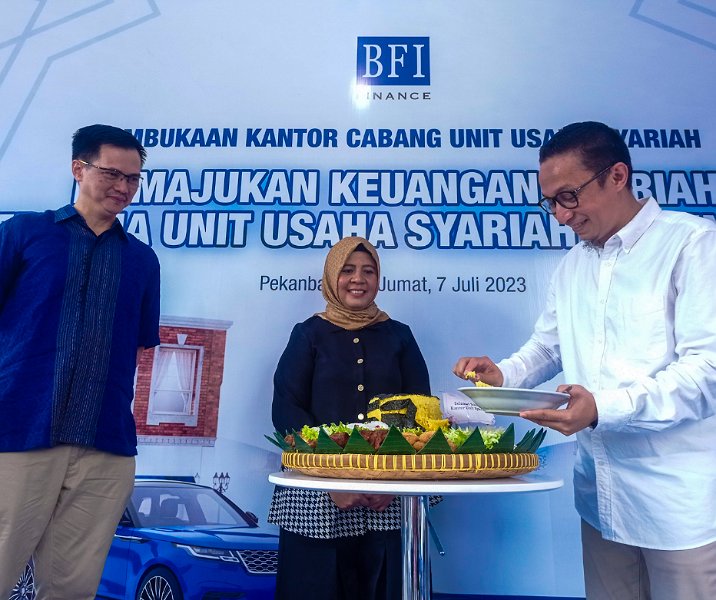 General Manager Business Regional Sumatera Sudihartono (kiri) menyaksikan Sharia Product Head BFI Deni Nasri memotong tumpeng saat peresmian Kantor BFI Finance Syariah Pekanbaru, Jumat (7/7/2023). Foto: Surya/Riau1.