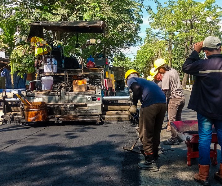 Pekerja perusahaan kontraktor saat proses overlay Jalan Parit Indah, Minggu (16/7/2023). Foto: Surya/Riau1.