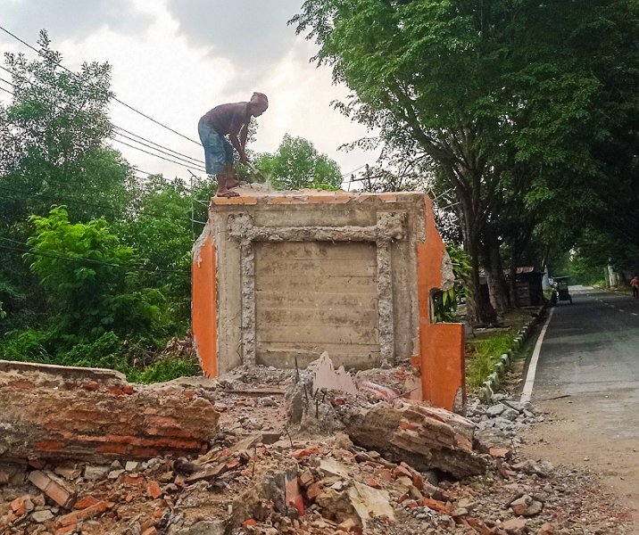 Seorang pekerja sedang menghancurkan gerbang Taman Labui pada 31 Agustus 2023. Foto: Surya/Riau1.