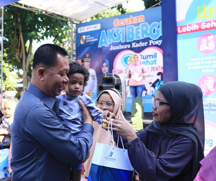 Sekdako Pekanbaru Indra Pomi Nasution saat menggendong balita di Jambore Kader Posyandu. Foto: Istimewa.