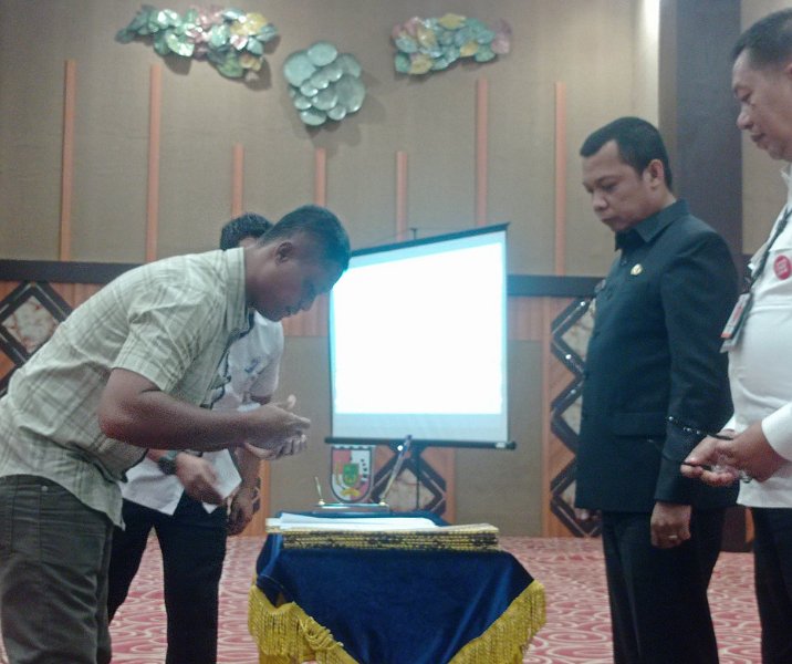 Direktur PT Thamrin Putra Pratama (developer) menandatangani berita acara serah terima aset PSU perumahan kepada Pemko Pekanbaru di Aula Gedung Utama Kompleks Perkantoran Tenayan Raya, Rabu (27/9/2023). Foto: Surya/Riau1.