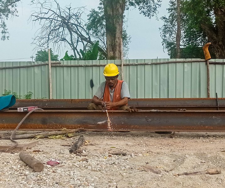 Seorang pekerja proyek revitalisasi Pasar Palapa sedang memotong rangka baja. Foto: Surya/Riau1.