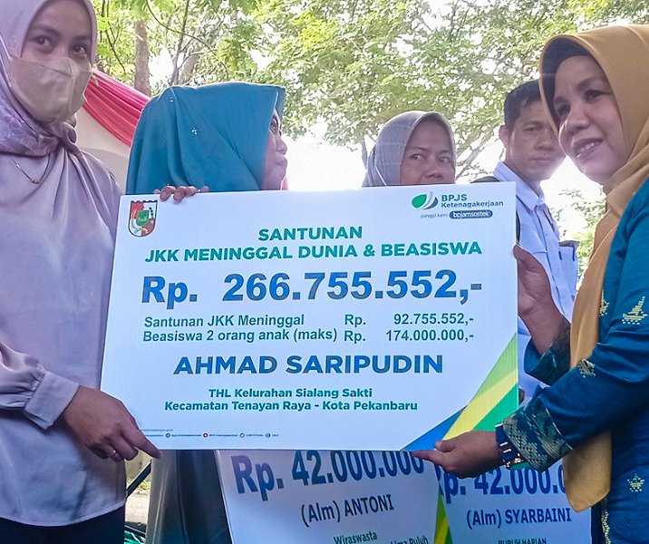 Ahli waris THL Pemko Pekanbaru menerima santunan kematian dan beasiswa bagi dua orang anak di taman kota, bawah Jembatan Siak I pada 24 November 2022. Foto: Surya/Riau1.