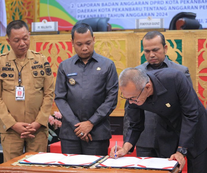 Pj Wali Kota Pekanbaru Muflihun menyaksikan salah seorang pimpinan DPRD menandatangani pengesahan APBD 2024 dalam rapat paripurna, Senin (20/11/2023). Foto: Istimewa.