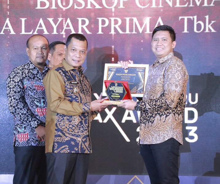 Pj Wali Kota Muflihun menyerahkan penghargaan kepada perwakilan Cinema SKA XXI dalam Pekanbaru Tax Award, Kamis (23/11/2023). Foto: Istimewa.