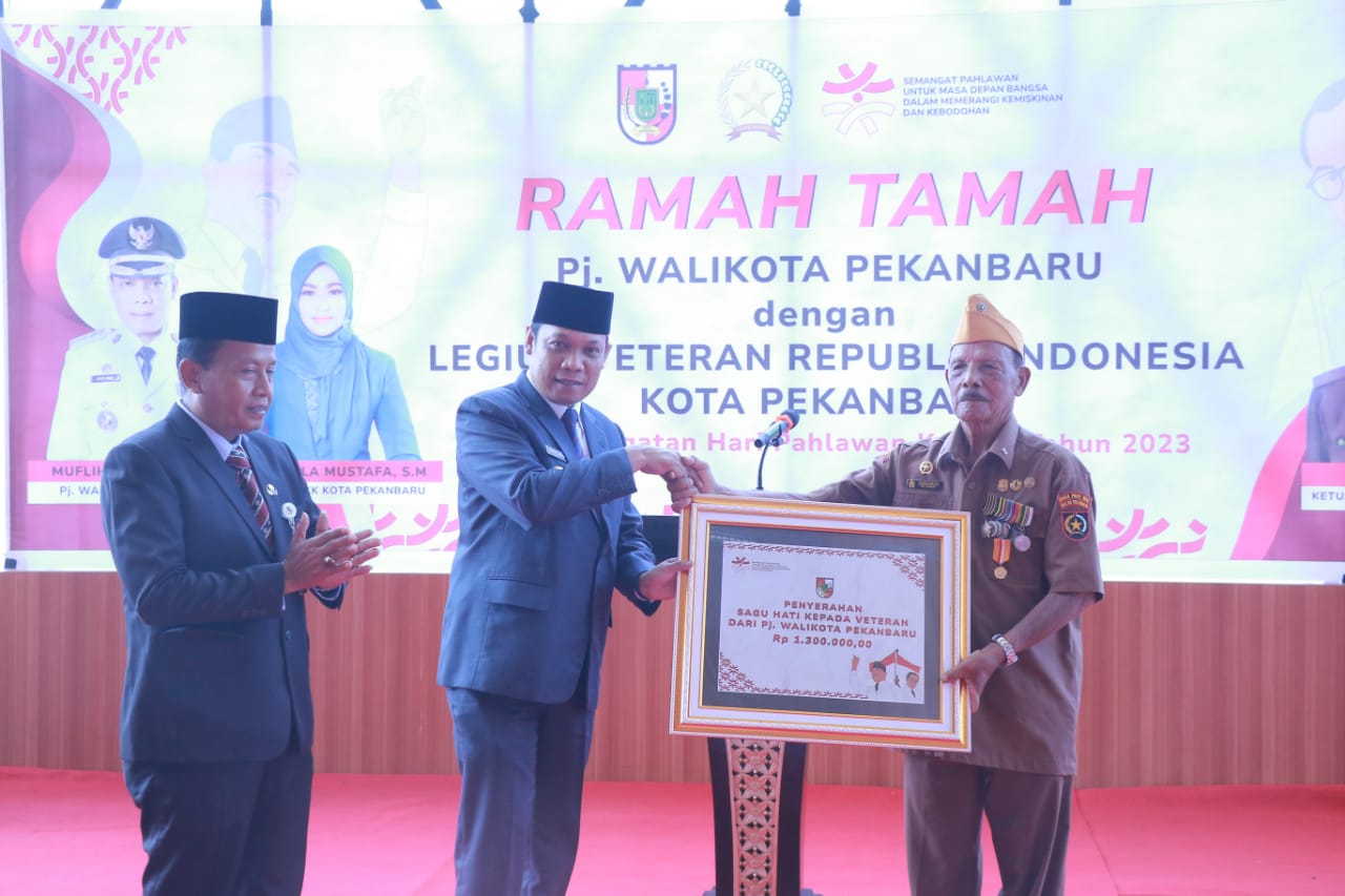 Pj Wali Kota Pekanbaru Muflihun didampingi Kepala Dinsos Idrus menyerahkan sagu hati secara simbolis kepada anggota Legiun Veteran Republik Indonesia, Jumat (10/11/2023).