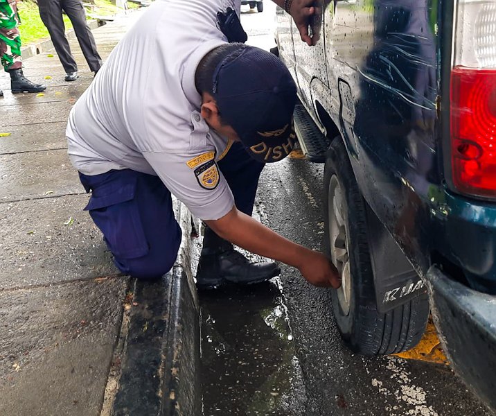 Petugas Dishub Pekanbaru menggembosi ban mobil di Jalan Diponegoro, depan RSUD Arifin Achmad, Kamis (30/11/2023). Foto: Istimewa.