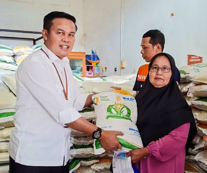 Kepala Disketapang Pekanbaru Maisisco menyerahkan beras bantuan pangan dari pusat kepada warga di Kantor Pos Indonesia, Rabu (6/12/2023). Foto: Istimewa.