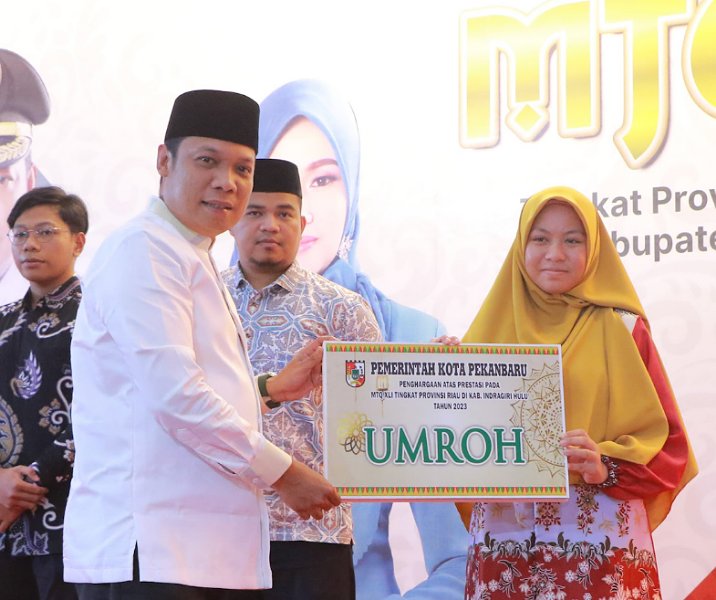 Pj Wali Kota Pekanbaru Muflihun memberikan hadian umrah secara simbolis kepada salah seorang juara MTQ Riau FI di kediaman wali kota, Jumat (8/12/2023). Foto: Istimewa.