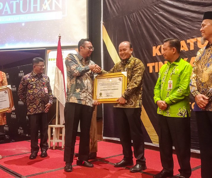 Asisten III Sekdako Pekanbaru Samto saat menerima penghargaan Kepatuhan Pelayanan Publik dari Ombudsman di Hotel Premiere, Selasa (19/12/2023). Foto: Surya/Riau1.