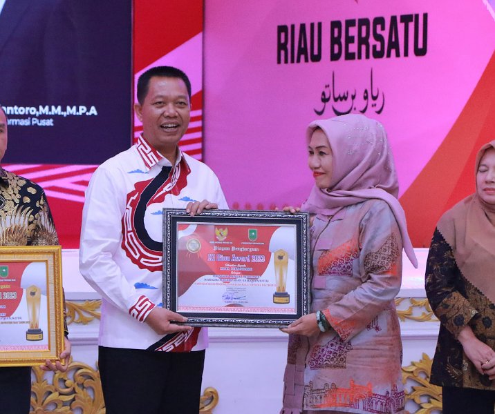 Sekdako Pekanbaru Indra Pomi Nasution mewakili pemko menerim penghargaan dari KI Riau kategori Menuju Informatif, Kamis (21/12/2023). Foto: Istimewa.