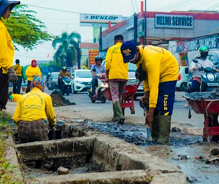 Pasukan kuning Dinas PUPR Pekanbaru saat membersihkan drainase. Foto: Istimewa.