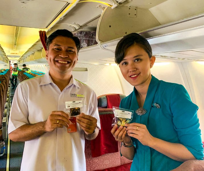 General Manager Whiz Prime Hotel Sudirman Pekanbaru Devy Antonius Malo bersama pramugari Garuda Indonesia membagikan Brocox kepada penumpang yang tiba di hari pertama tahun 2024 di Bandara SSK II, Senin (1/1/2024). Foto: Istimewa.