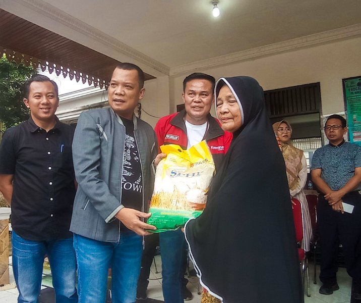 Pj Wali Kota Pekanbaru Muflihun secara simbolis menyerahkan paket sembako kepada pembeli di pasar murah yang digelar di halaman Kantor Kelurahan Mentangor, Kulim, pada 30 Desember 2023. Foto: Istimewa.