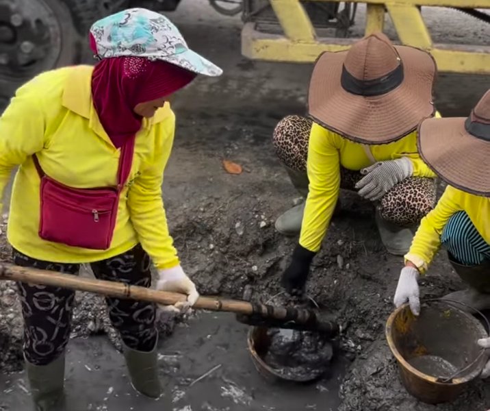 Pasukan kuning Dinas PUPR Pekanbaru membersihkan drainase Jalan Dharma Bakti. Foto: Istimewa.