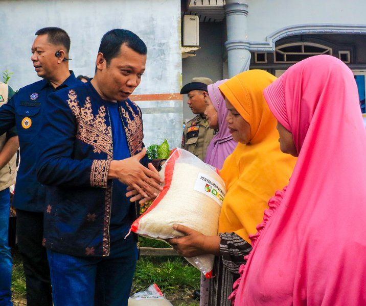 Pj Wali Kota Pekanbaru Muflihun menyerahkan beras CPPD kepada korban banjir di Jalan Nelayan, Kelurahan Sri Meranti, Kecamatan Rumbai, Minggu (28/1/2024). Foto: Istimewa.