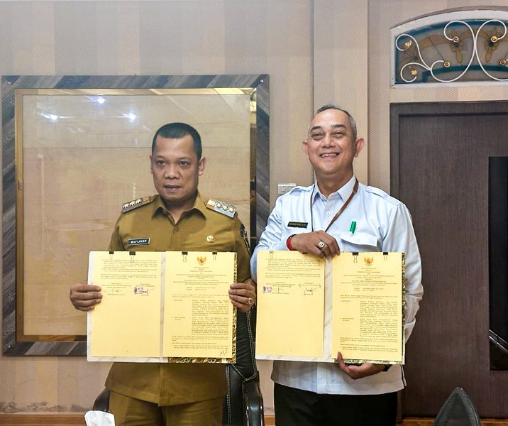 Pj Wali Kota Pekanbaru Muflihun bersama Kepala BPJS Ketenagakerjaan Iman Santoso Achwan melihat nota kesepahaman usai penandatanganan di kediaman wali kota, Senin (12/2/2024). Foto: Istimewa.