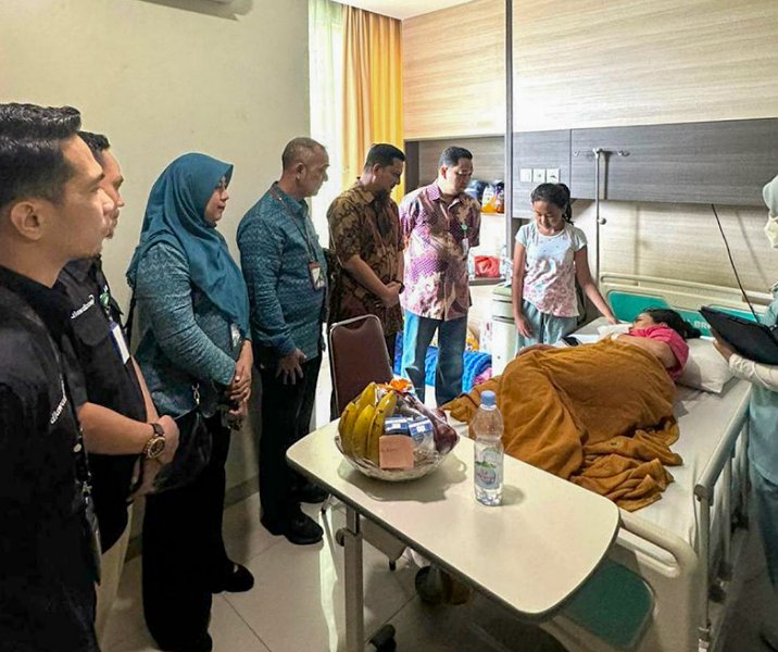 Kepala BPJS Ketenagakerjaan Iman Santoso Achwan bersama Kabag Tapem Setdako Pekanbaru Syafrian Tomi menjenguk petugas KPPS yang ditimpa pohon usai pulang mencoblos di TPS lain, Kamis (15/2/2024). Foto: Istimewa.