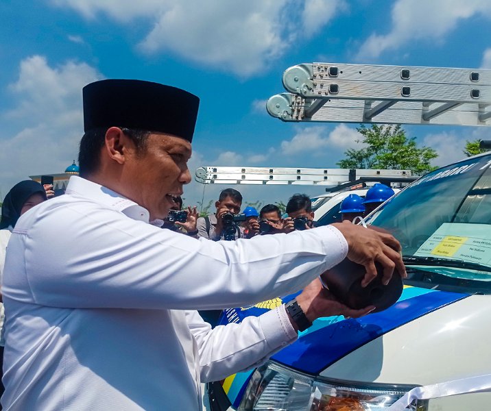 Pj Wali Kota Pekanbaru Muflihun menyiramkan air kendi ke salah satu mobil layanan PJU sebagai tanda beroperasinya mobil tersebut, Rabu (13/3/2024). Foto: Surya/Riau1.